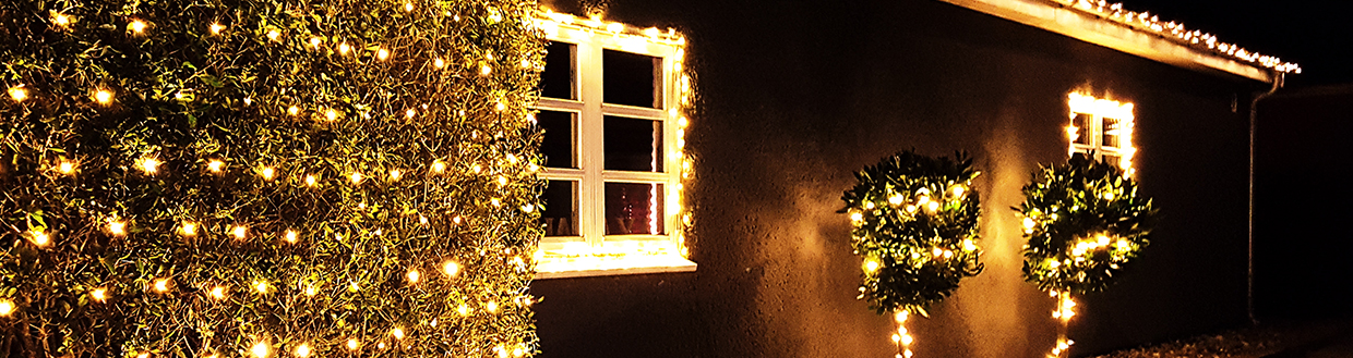 Dům s vánočním osvětlením pověšeným na střeše.
